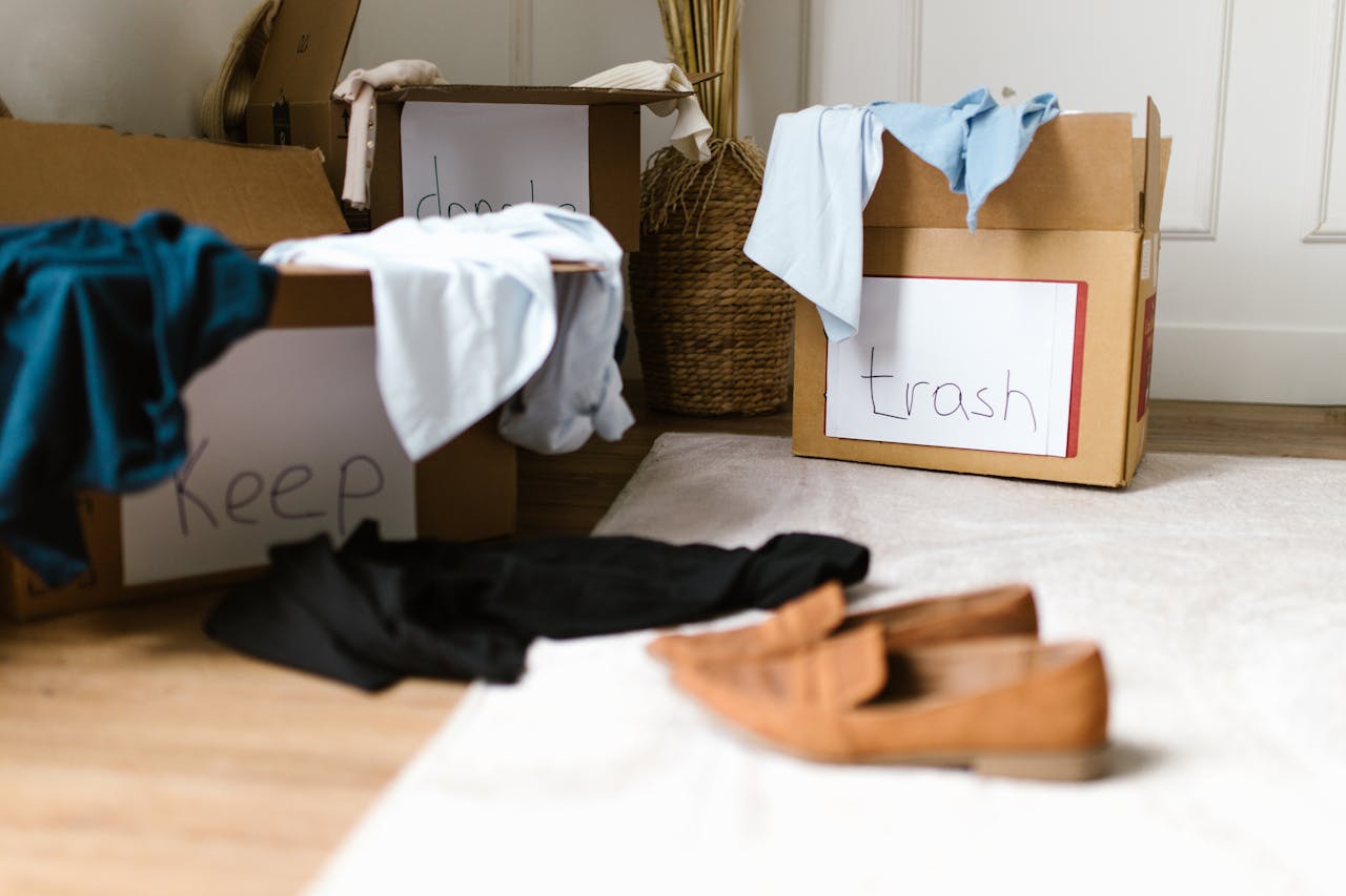 client-satisfaction-img Decluttering concept using labeled boxes for sorting clothes in a home setting.